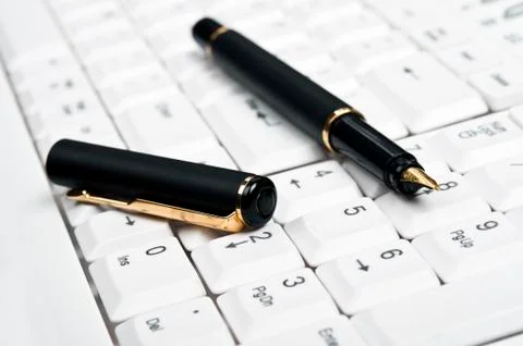 Pen on keyboard Stock Photos