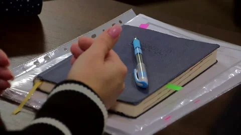 The pen lies on top of the notepad in front of the gesturing hands. Stock Footage 324766203