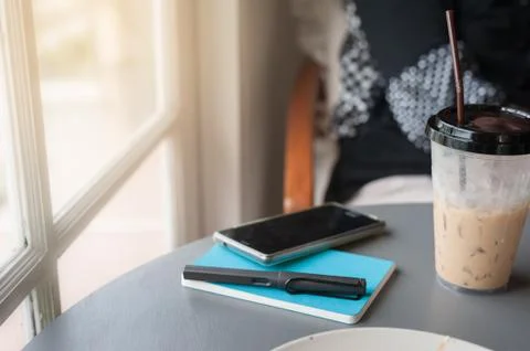 Pen, notebook, and smartphone on table Stock Photos