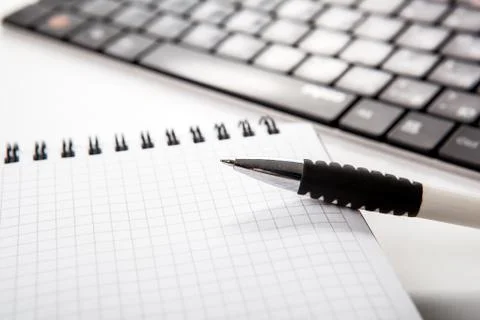 Pen on a notebook into a cell and keyboard Stock-Fotos