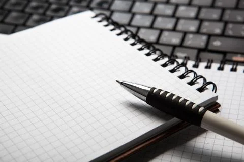 Pen on a notebook into a cell and keyboard Foto stock