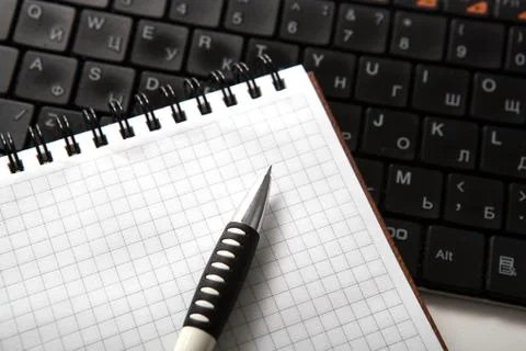 Pen on a notebook into a cell and keyboard Stock Photos