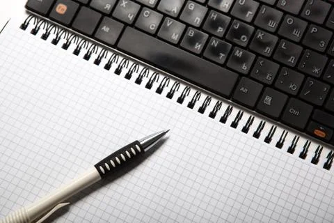 Pen on a notebook into a cell and keyboard Stock-Fotos