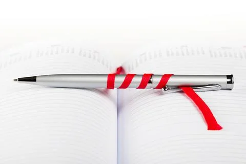 Pen on notebook with red string silver pen on opened notebook with red str... 스톡 사진