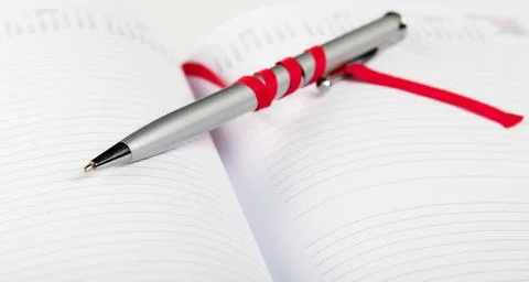 Pen on notebook with red string silver pen on opened notebook with red str... 스톡 사진