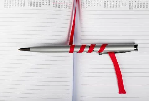 Pen on notebook with red string silver pen on opened notebook with red str... 스톡 사진
