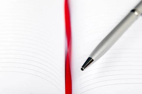 Pen on notebook with red string silver pen on opened notebook with red str... 스톡 사진