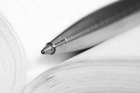 Pen on a opened book Stock Photos