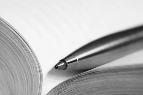 Pen on a opened book Stock Photos