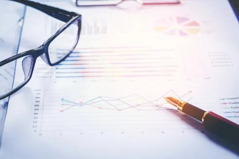 Pen is on summary report on table office. Stock Photos