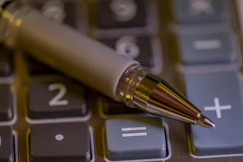 A pen is on top of a calculator Stock-Fotos