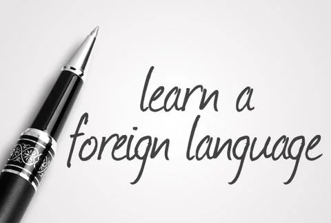 Pen writes learn a foreign language on white blank paper Foto stock