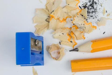 Pencil and sharpener on a white table. Accessories for drawing and sketching. Stock Photos