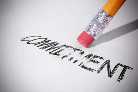 Pencil erasing the word Commitment Stock Photos