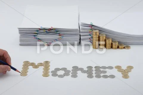 Pencil in man's hand with sort coins as money Stock Photos