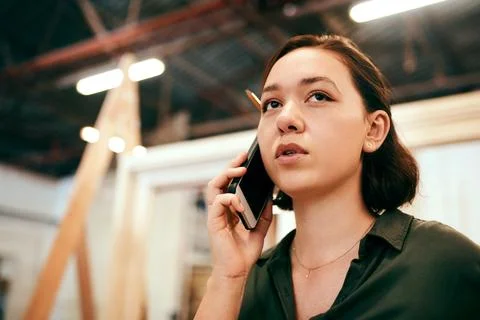 Pencil, phone call and problem solving with carpenter woman in workshop for Foto stock