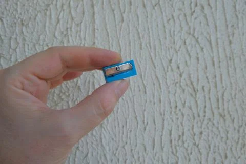 Pencil sharpener in mans hand on light background Stock Photos