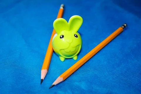 Pencil sharpener in the shape of a hare and next to it are two simple pencils 스톡 사진