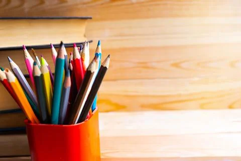 Pencil stand and a stack of books on wooden background. Copy space for the te Stock Photos