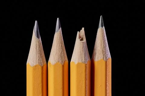 Pencil tips on black background, one broken 写真素材