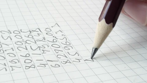 Pencil is writing figures in the note pad. Close up. Stock Footage 107329015