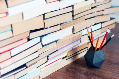 Pencils in holder and stack of books, school background for education learnin Stock Photos