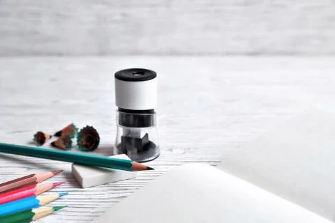 Pencils, notepad, sharpener, eraser and shavings from pencils on a gray non-u Stock Photos