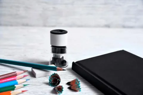 Pencils, notepad, sharpener, eraser and shavings from pencils on a gray non-u Stock Photos