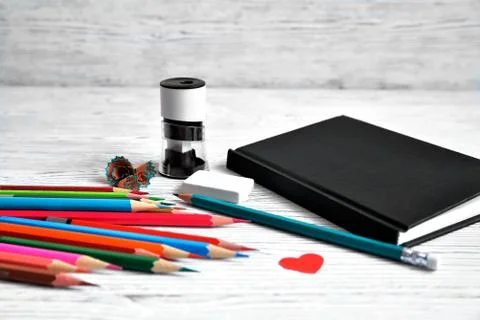 Pencils, notepad, sharpener, eraser and shavings from pencils on a gray non-u Stock Photos
