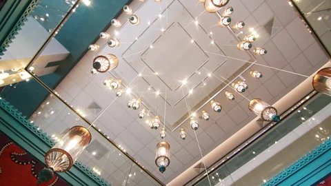 Pendant lights hang on chains in high Tatar-style hall Stock Footage 290512555