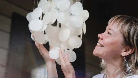 A pendant of white shells swings and jingles in the wind. Wind chime. A cute Stock Footage 305864622