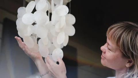 A pendant of white shells swings and jingles in the wind. Wind chime. A cute Stock Footage 306278767