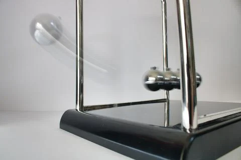 Pendulum in motion demonstrating physics principles indoors Stock Photos