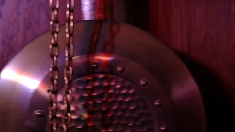 The pendulum of an old mechanical clock swinging in purple-pink light Stock Footage 218318246