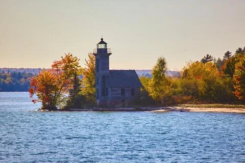 Peninsula with a lighthouse and fall or summer forest and a sandy beach and blue Stock Photos