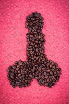 Penis make from coffee beans on red cloth background Stock Photos