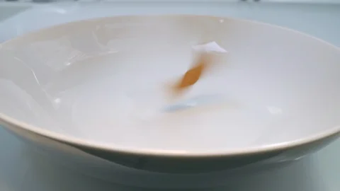 Penne pasta falls on the white plate in slow motion Stock Footage