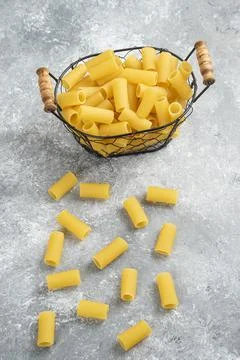 Penne pasta in a metallic container on grey marble background Stock Photos