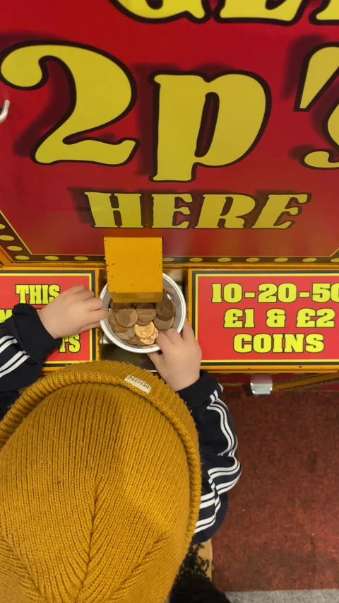 Penny change machine in an amusement arcade young boy overhead shot Stock Footage 239411961