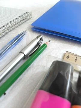 Pens, notepad, blue folder, pencils, markers, ruler on the desktop. The begin Stock Photos
