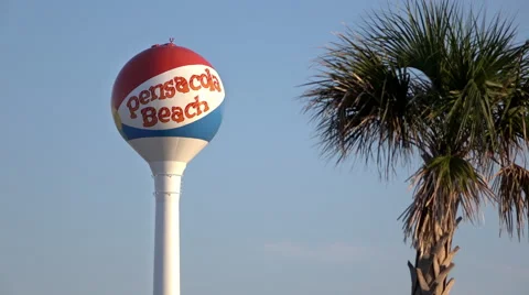 Pensacola Beach water tower with palm tree in foreground 4k Stock Footage