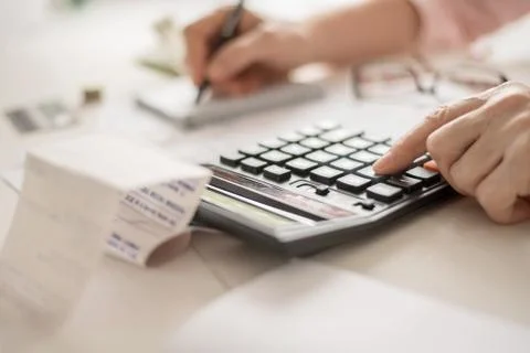 Pension calculation concept, old hands counting finances on a home calculator Stock Photos
