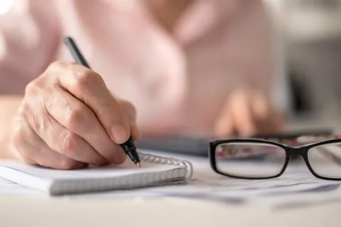 Pension calculation concept, old hands counting finances on a home calculator Stock Photos