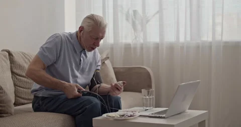 Pensioner checking blood pressure during video call Stock Footage 196237617