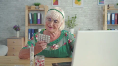 Pensioner is looking for information on the Internet about the pills sitting at Stock Footage 113741783