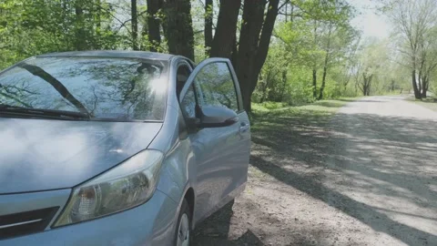 Pensioner opens door gets out of grey car and waves hand Stock Footage 136426496