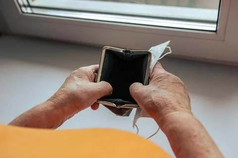 A pensioner opens a wallet. empty wallet in the hands of an elderly woman.  Stock Photos