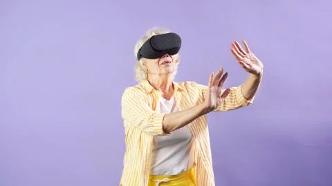 Pensioner posing in the Studio using VR glasses. Isolated background Stock Photos