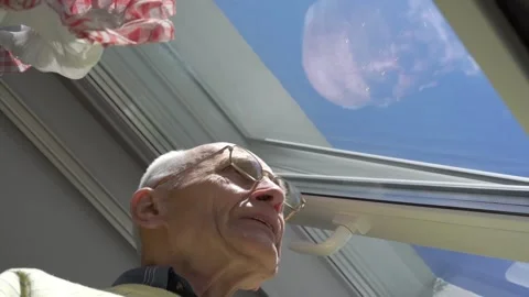 Pensioner reflected in window glass waves hand low angle Stock Footage 134998206
