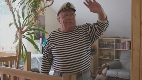 Pensioner in sailor cap waves hand and takes selfie stick Stock Footage 136426724